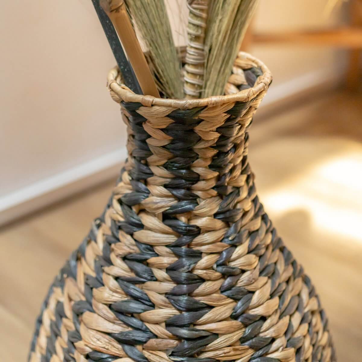 Decoratieve handgemaakte boho vaas van waterhyacint, gestreept patroon in naturel en zwart, perfect voor droogbloemen.