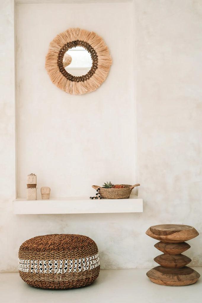 Boho spiegel Mowgli aan de muur in lichte ruimte met houten decoratieve items; creëer sfeer, licht en diepte in je interieur.