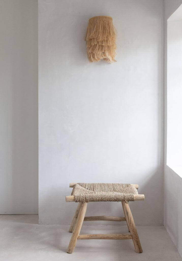 Natuurlijke Abaca applique muurlamp in een minimalistisch interieur met houten krukje. Stijlvol en handgemaakt, geen bekabeling inbegrepen.