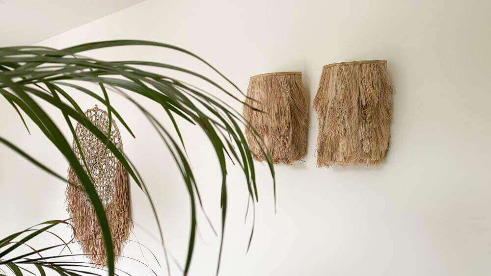 Twee natuurlijke Abaca muurlampen in een woonkamer, geïnspireerd door de natuur. Handgemaakt voor een ontspannen en stijlvolle sfeer.