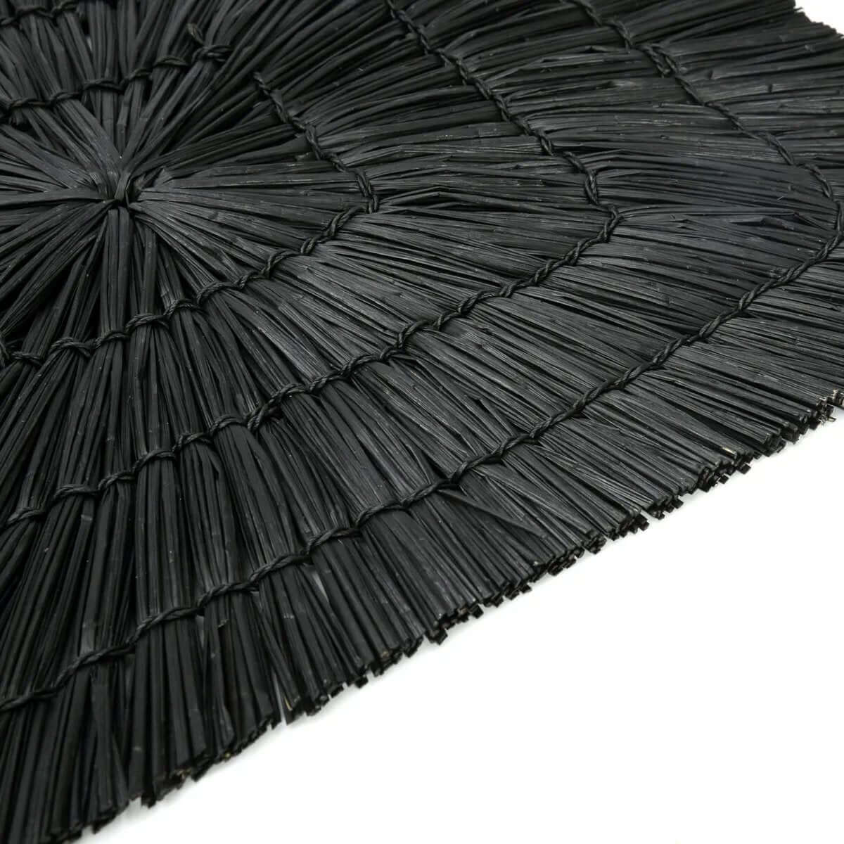 Elegant black rectangular placemat made of grass, adding a bohemian touch to your table. Perfect for any interior or exterior setup.
