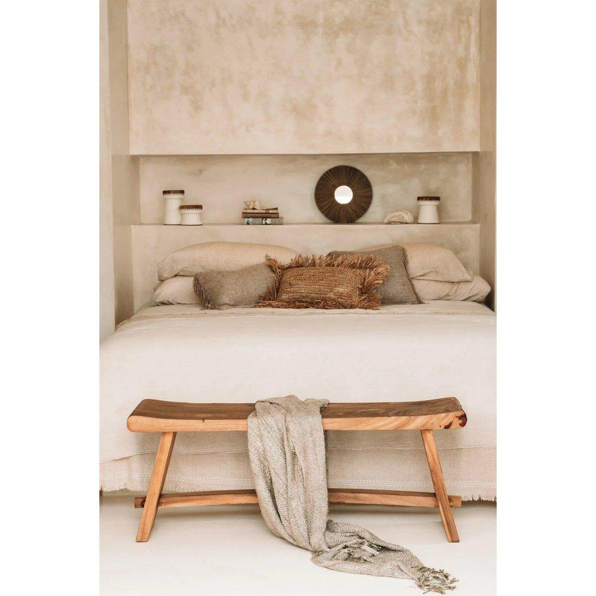 Stijlvolle slaapkamer met beige beddengoed, zeegras kussen en houten bankje voor een boho-sfeer, inclusief De Alang Alang spiegel.