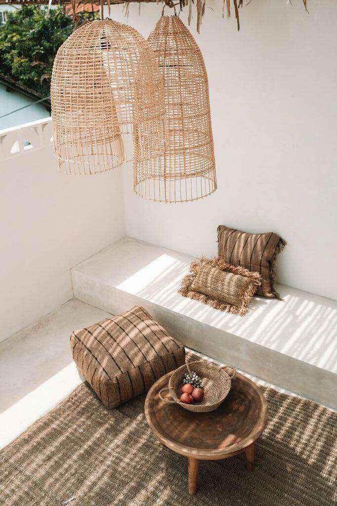 Rotan hanglampen en natuurlijke inrichting in mediterraan interieur op terras, geïnspireerd door de kuststijl van Amalfi.