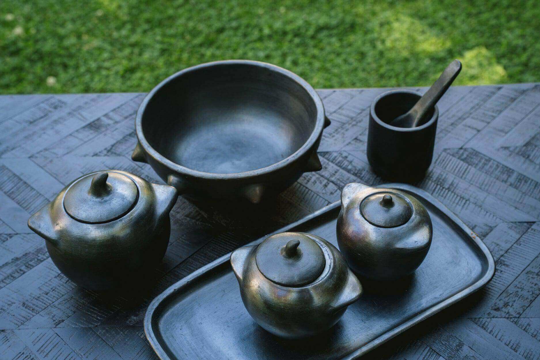 Teakhouten kom en schalen op een houten tafel, perfect voor accessoires of hapjes, handgemaakt en zwarte kleur.
