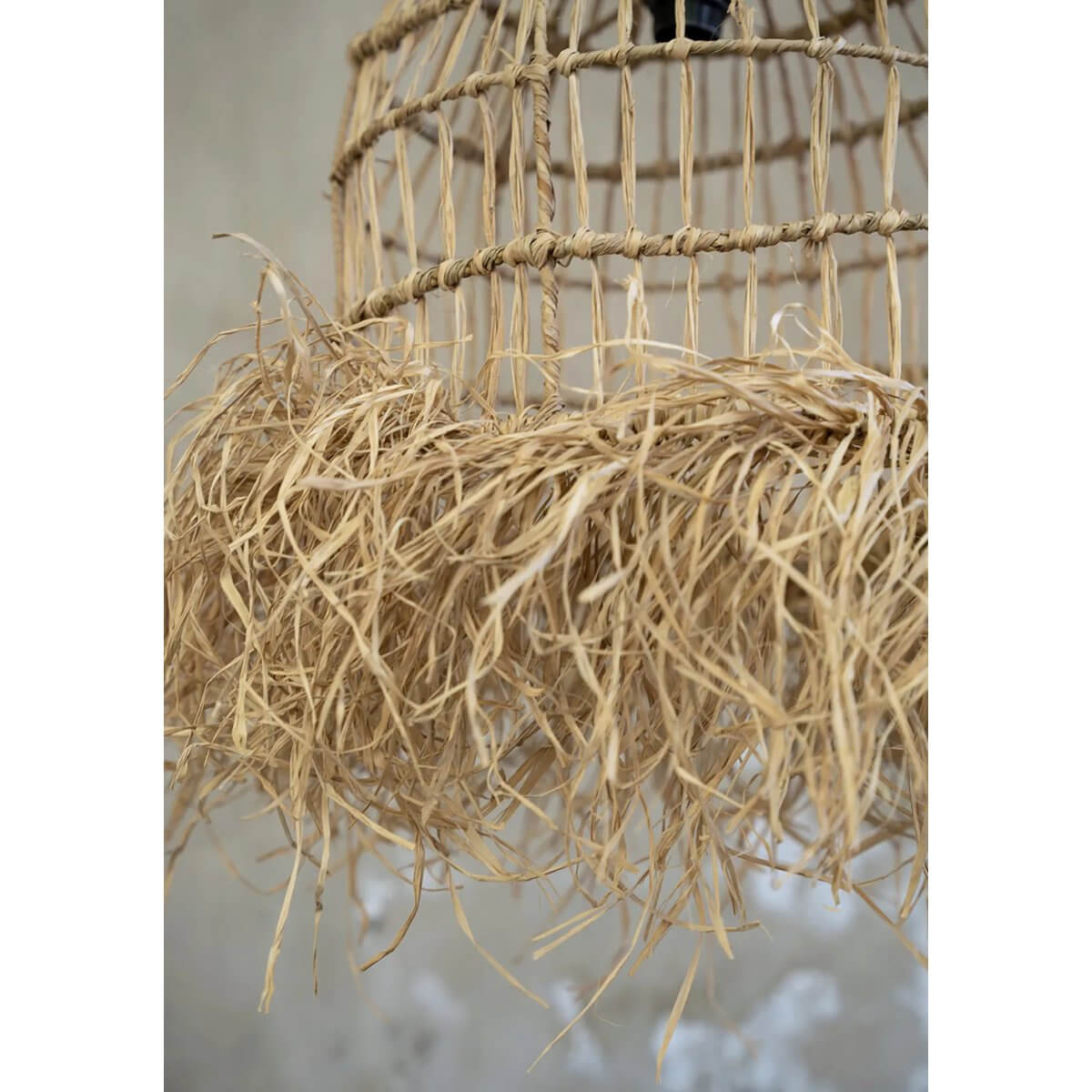 De Casita hanglamp in naturel, gemaakt van mendonggras, brengt tropische vibes met zijn franjes voor sfeervolle lichtpatronen.
