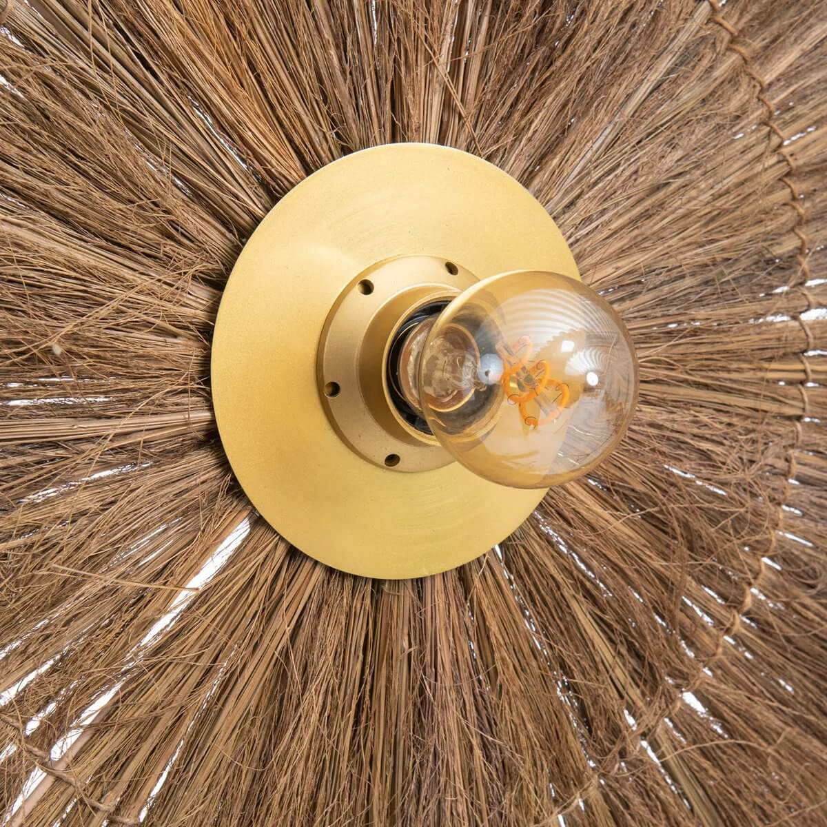 De Chi-Chi wandlamp van natuurlijk messing met grasstructuur, perfect voor stijlvol licht in donkere gangen of overdekte ruimtes.