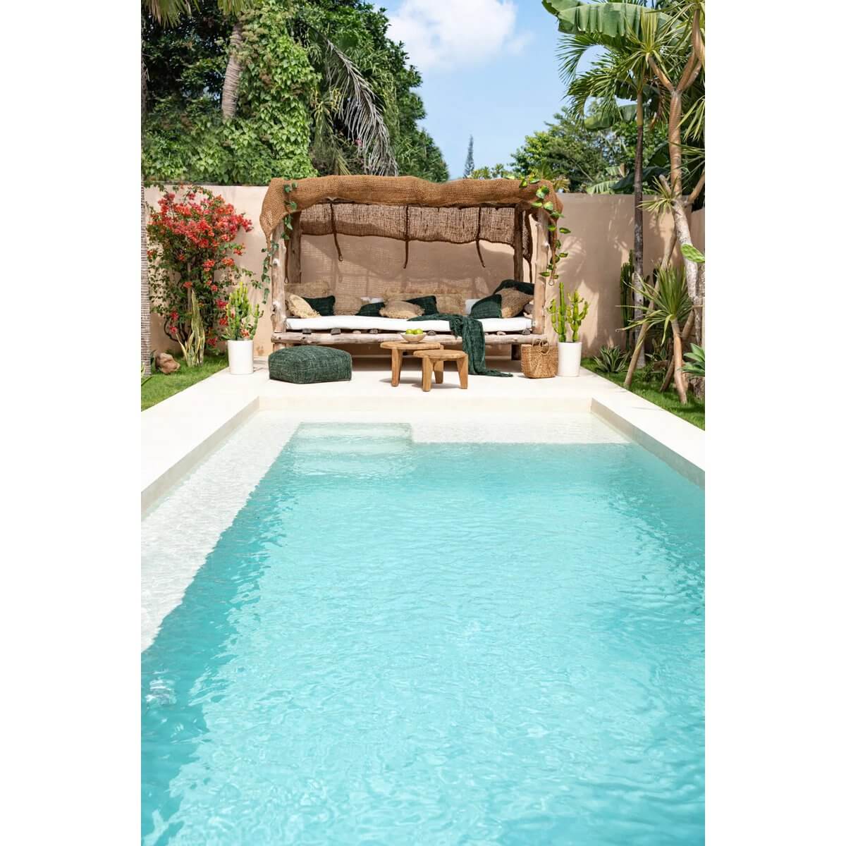 Luxurious backyard pool with a bohemian-style coco shade canopy and lush green garden, perfect for relaxation.