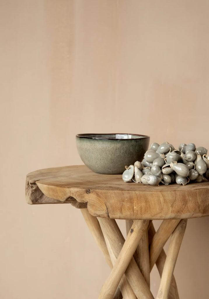 Portugese keramische kom op houten tafel met decoratieve kralen, ideaal voor een stijlvolle brunch of diner. De Comporta Collection.