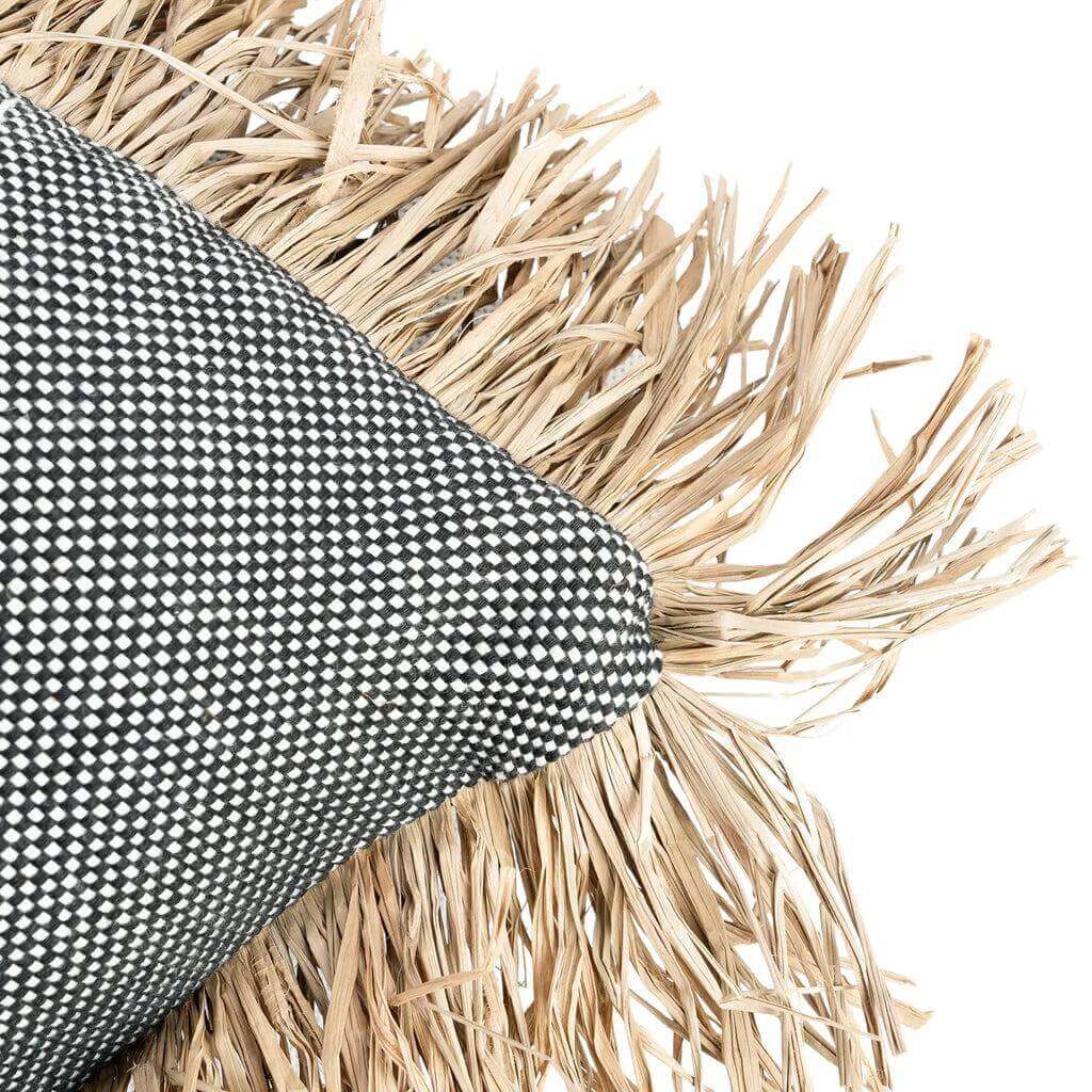 Zwart-wit gestippelde kussenhoes met raffia franjes voor een stijlvolle strand-look, ideaal voor interieur of tuin. "De Cotton Bonita" stijl.