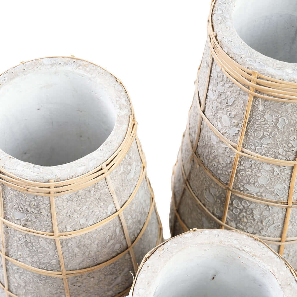 Colletie van terracotta vazen met rotan detail in betongrijs naturel, perfect voor droge bloemen in huislijke ruimte.