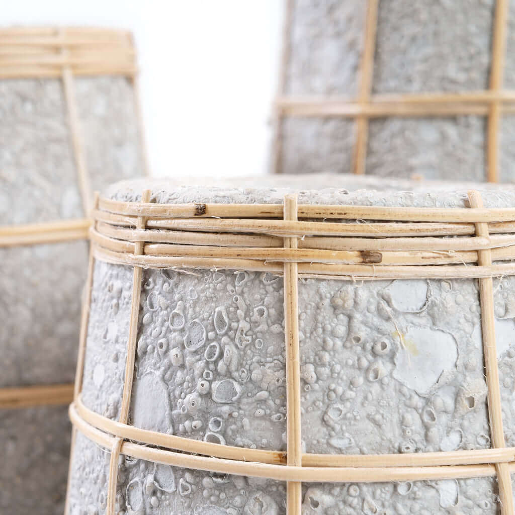 Close-up van De Cutie Vaas in betongrijs met natuurlijke rotan details, perfect voor droge bloemen.