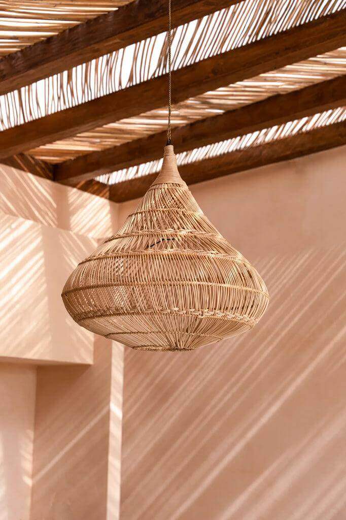 XL rotan hanglamp in druppelvorm, natuurlijk kleur, onder zonnige pergola, creëert een sfeervol lichteffect in elke ruimte.