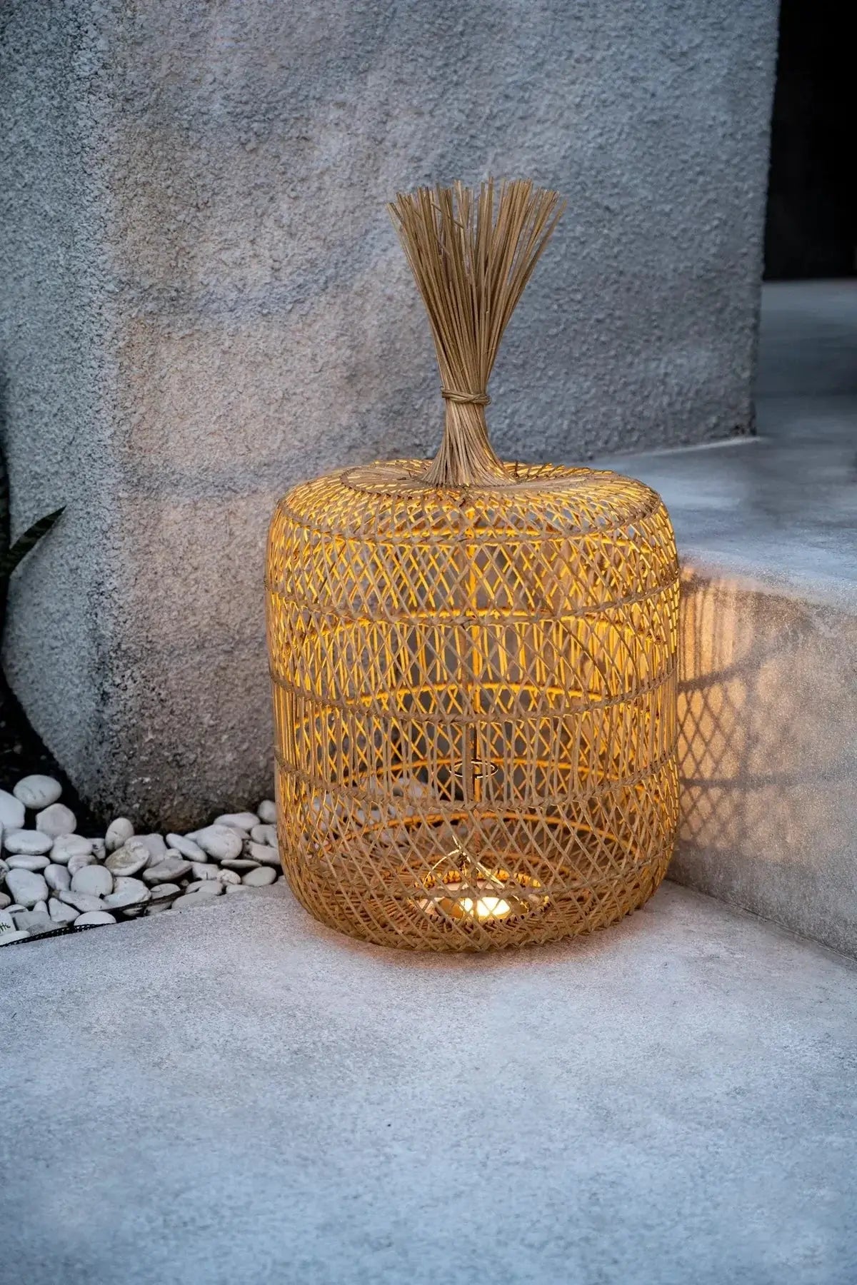 Stijlvolle rotan De Dumpling Hang- en Vloerlamp - Naturel, sfeervol verlicht op een trap, perfect voor een boho interieur.
