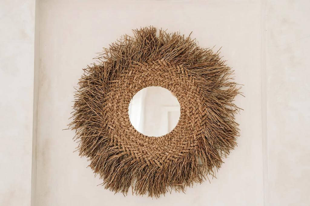 Ronde rotan spiegel met franjes, voegt boho en kusttextuur toe aan jouw interieur. Afmetingen 75x75 cm, spiegelglas diameter 25 cm, kleur naturel.