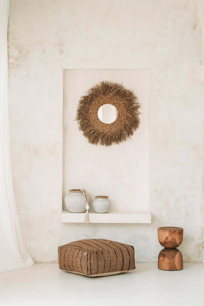 Alt Tag: "De Early Monday Spiegel met rotan en franjes aan de muur, brengt een boho kusttextuur in uw interieur."