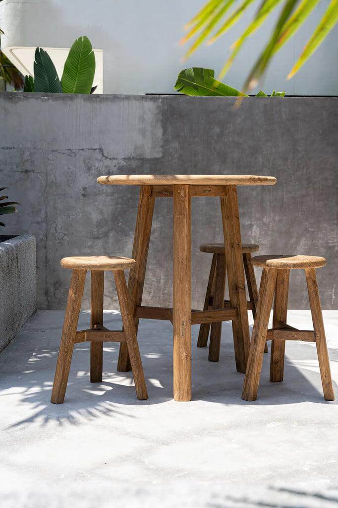 Handgemaakte Fusuma Bartafel van gerecycled teakhout met krukken, duurzaam en stijlvol voor buitengebruik op zonnige patio.