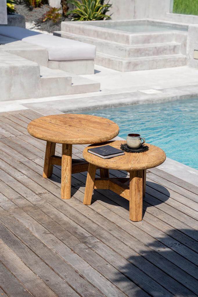 Twee ronde Fusuma salontafels van gerecycled teakhout naast het zwembad, perfect voor ruimtebesparende interieurstijlen.