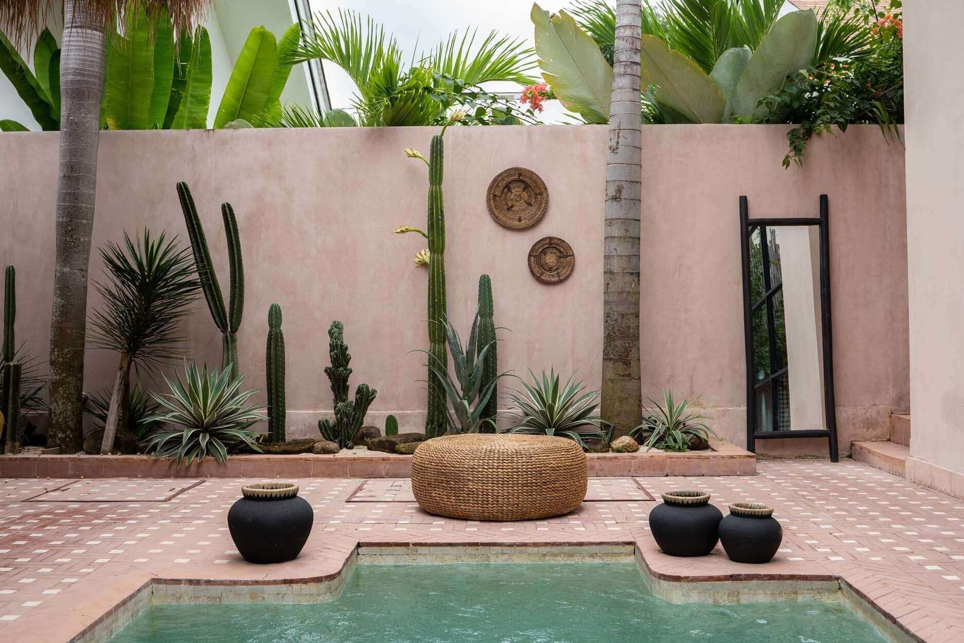 Alt Tag: Stijlvolle De Hyacinth Poef in boho tuindecor met natuurlijke accenten en cactussen naast zwembad.