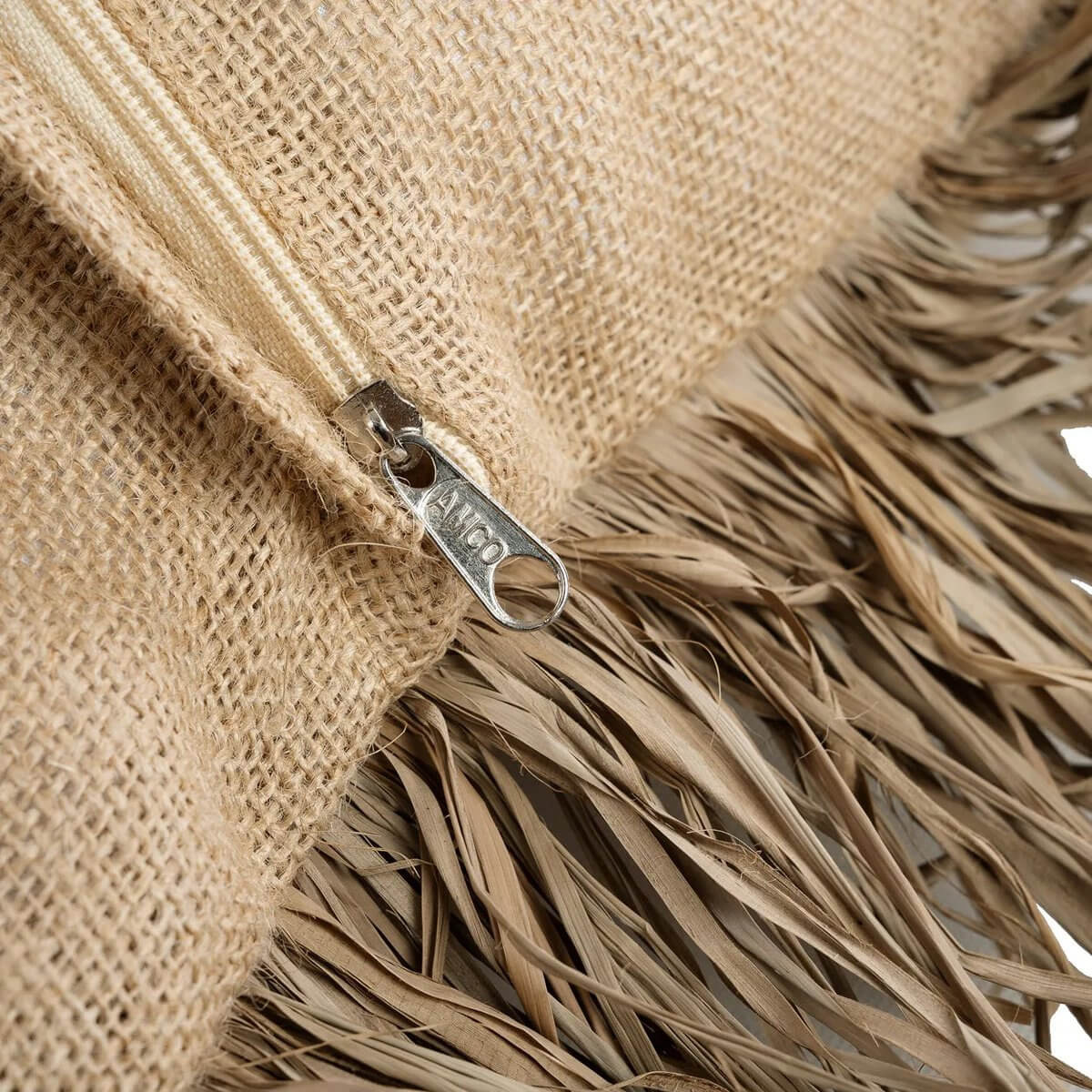 Close-up van de jute kussenhoes met raffia-franjes en ritssluiting van Bazar Bizar Living, 60x60 cm, beige kleur.