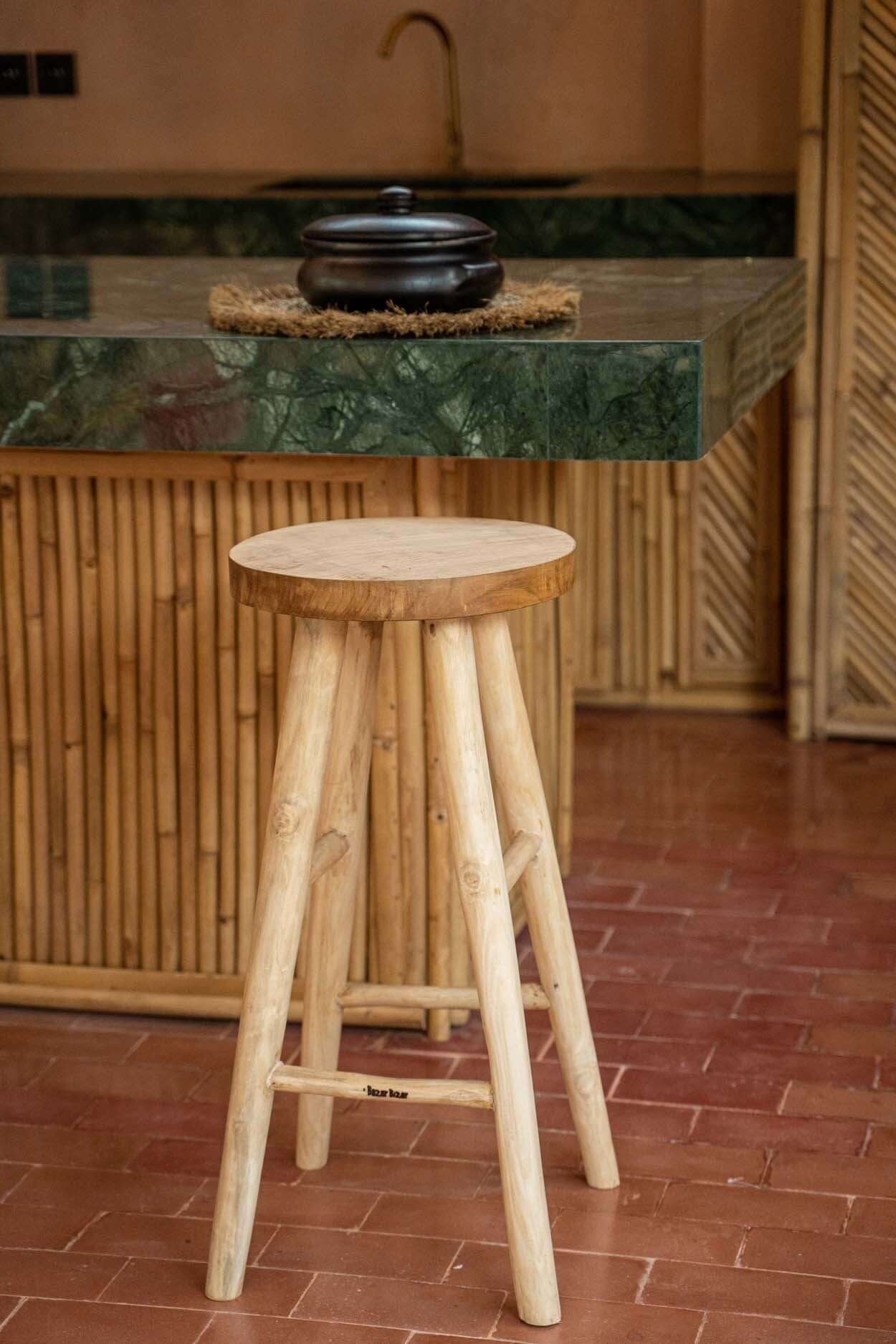 Elegante Kedut barkruk van massief teak bij buitenbar op terras, perfect voor tuinfeestjes en BBQ's.