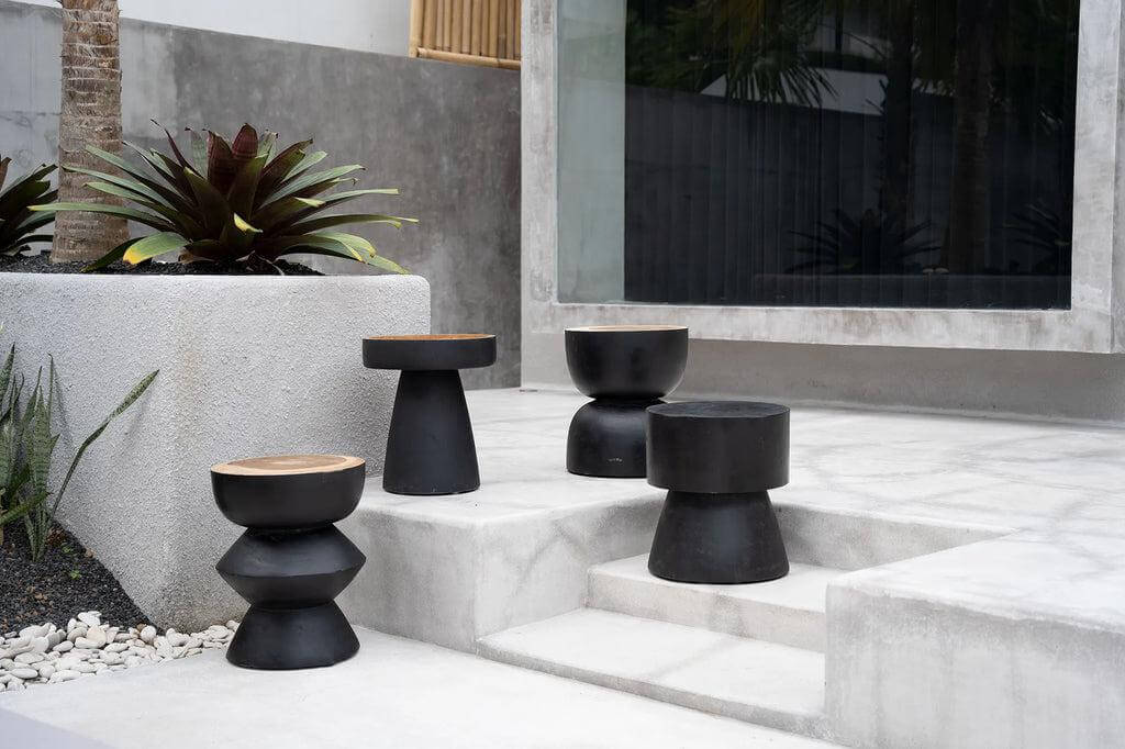 Verschillende moderne zwarte Kulun krukken buiten op terras, gemaakt van handbewerkt Indonesisch suarhout. Stijlvolle, minimalistische uitstraling.