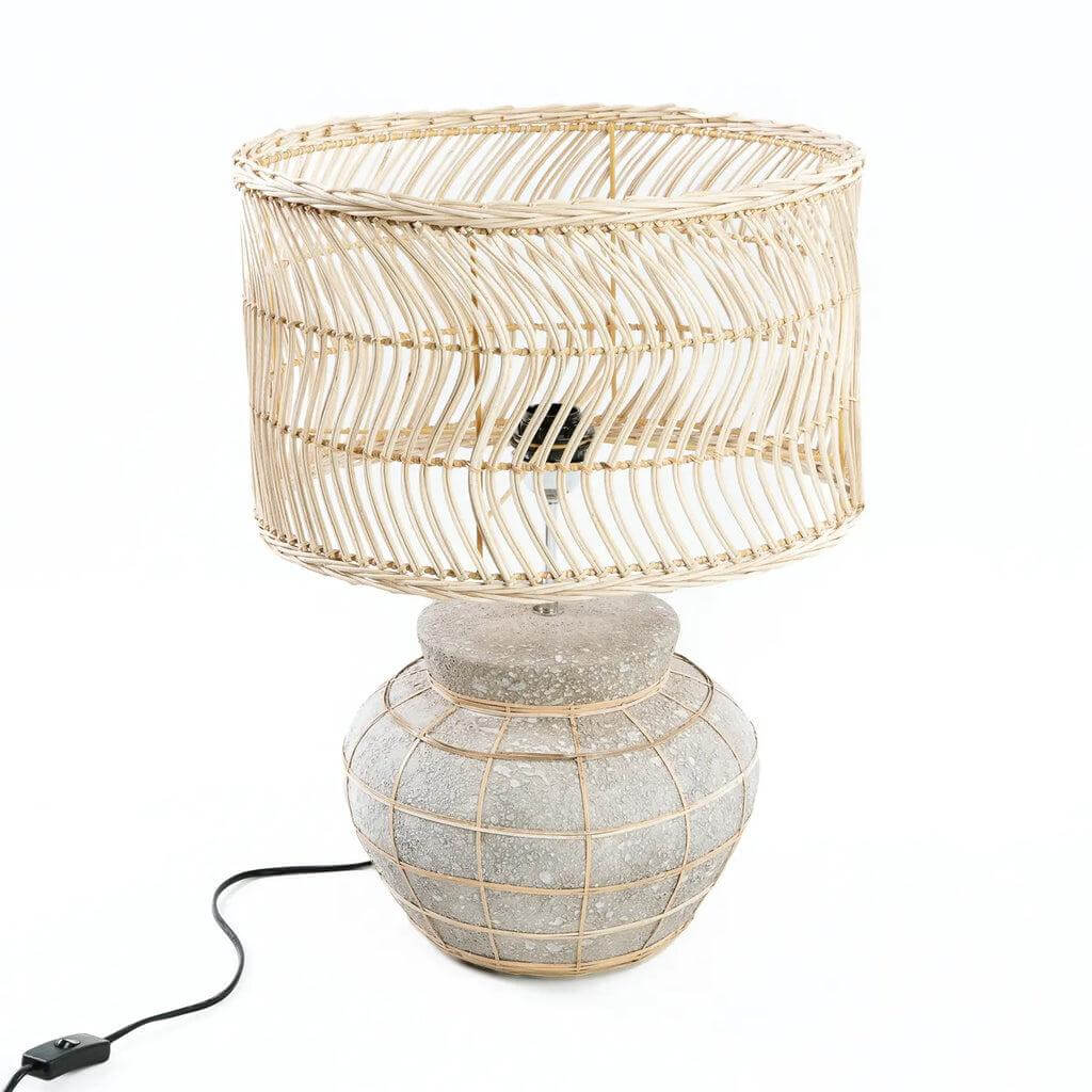 De Kythira tafellamp met ronde terracotta basis en rotan kap, in naturel betongrijs. Perfect voor nachtkastje of console tafel.