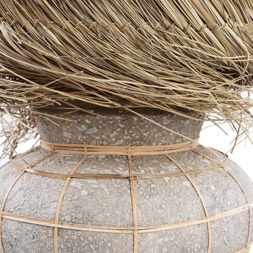 Close-up van Lipsi tafellamp met betongrijs terracotta voet en rotan grid, pandangras lampenkap. Sfeervol design accent voor elke kamer.