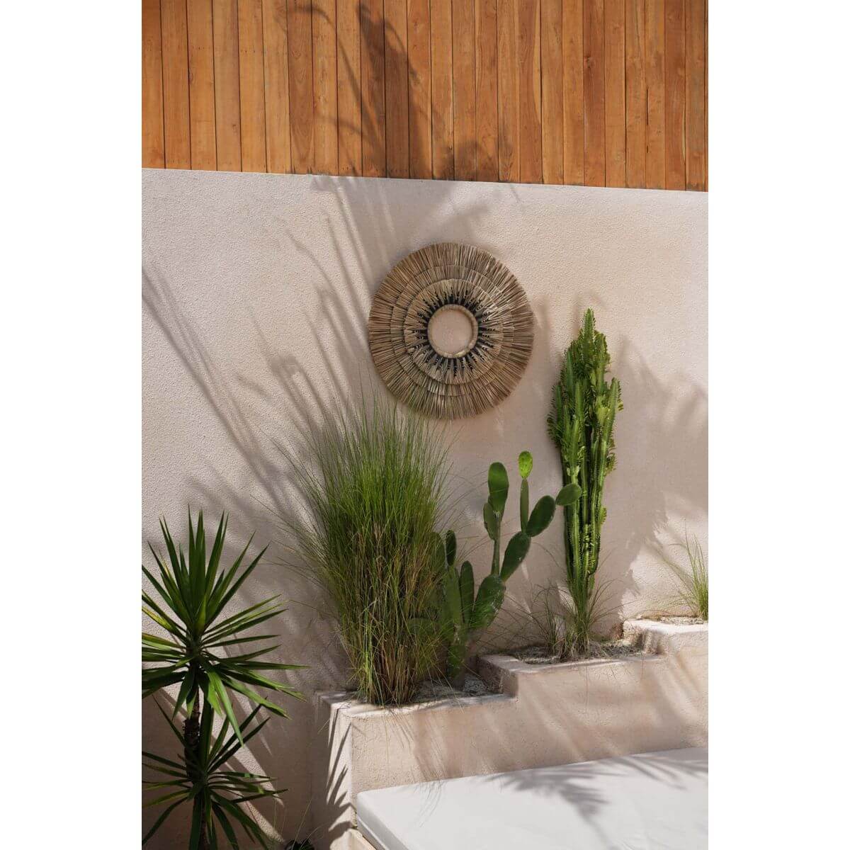 Bohemien muurdecoratie van Mengdong-gras en zwart katoen aan muur met groene planten, perfect voor rustiek interieur.