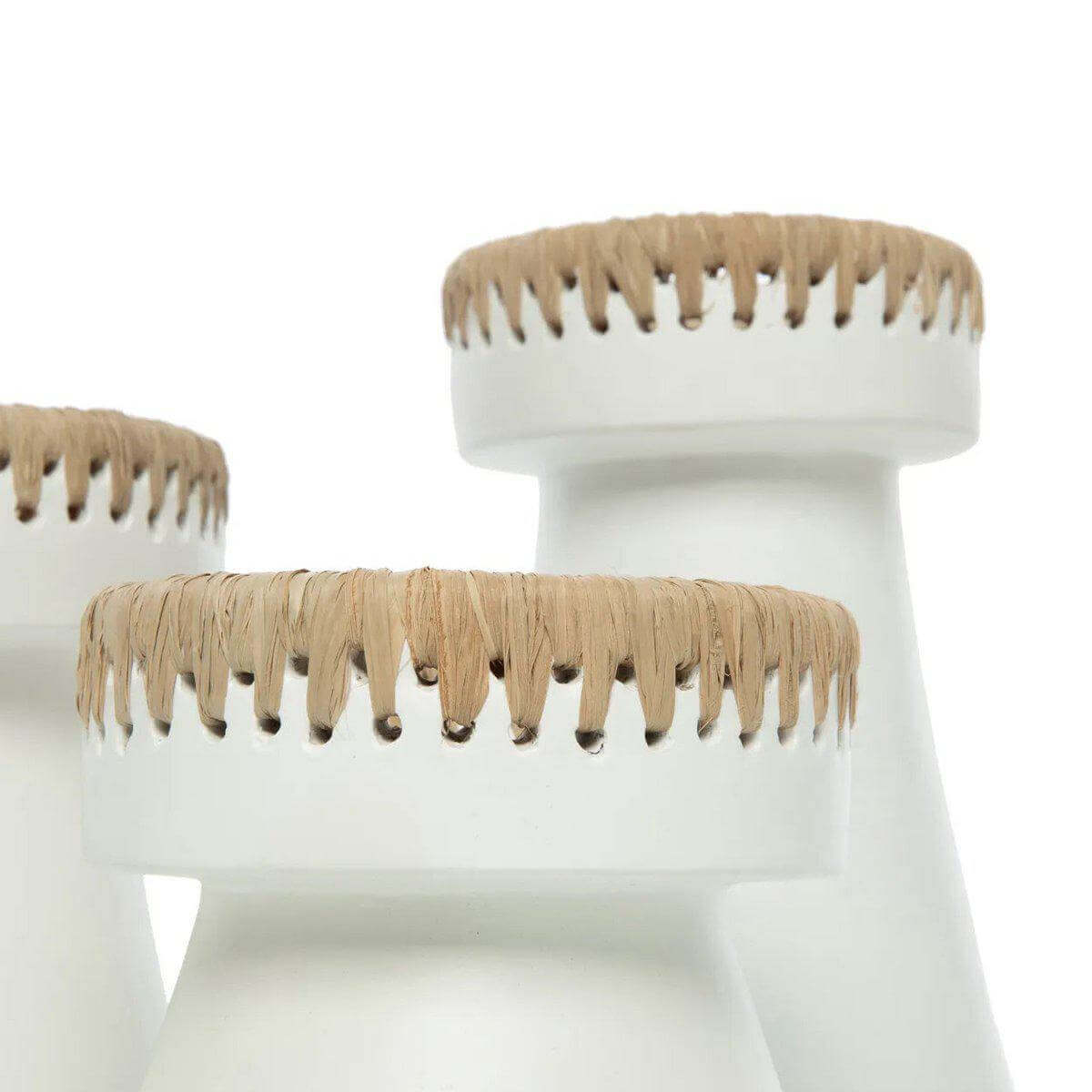 Stijlvolle witte terracotta kaarsenhouder met raffia-accenten, perfect voor een moderne interieurinrichting.