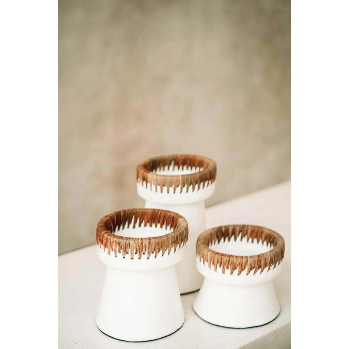 Set van drie witte terracotta kandelaren met raffia-accenten, decoratieve en stijlvolle toevoeging voor elke ruimte.