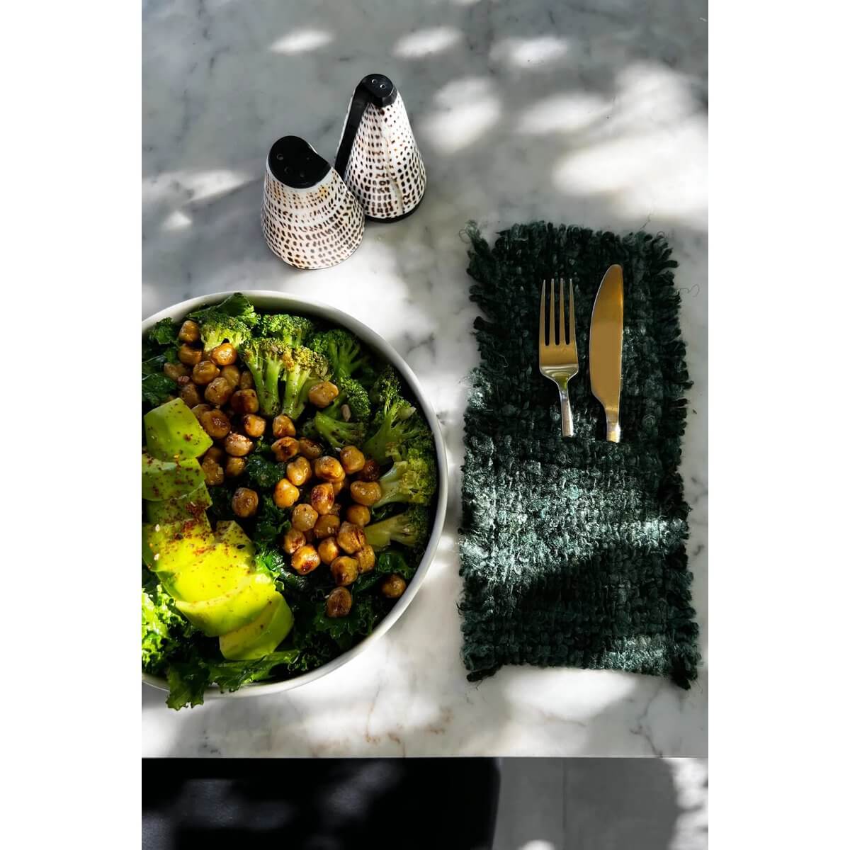 Bohemian Bosgroen bestekhouder, set of 4, on a table with a salad and salt & pepper shakers.