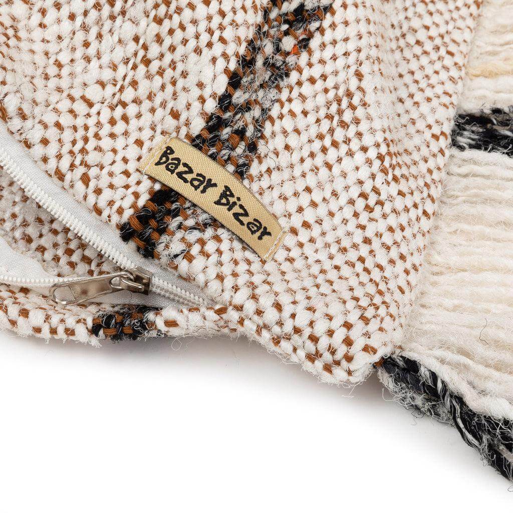 Close-up van de Bohemian witte kussenhoes met rits en label voor een stijlvolle boho uitstraling in huis.