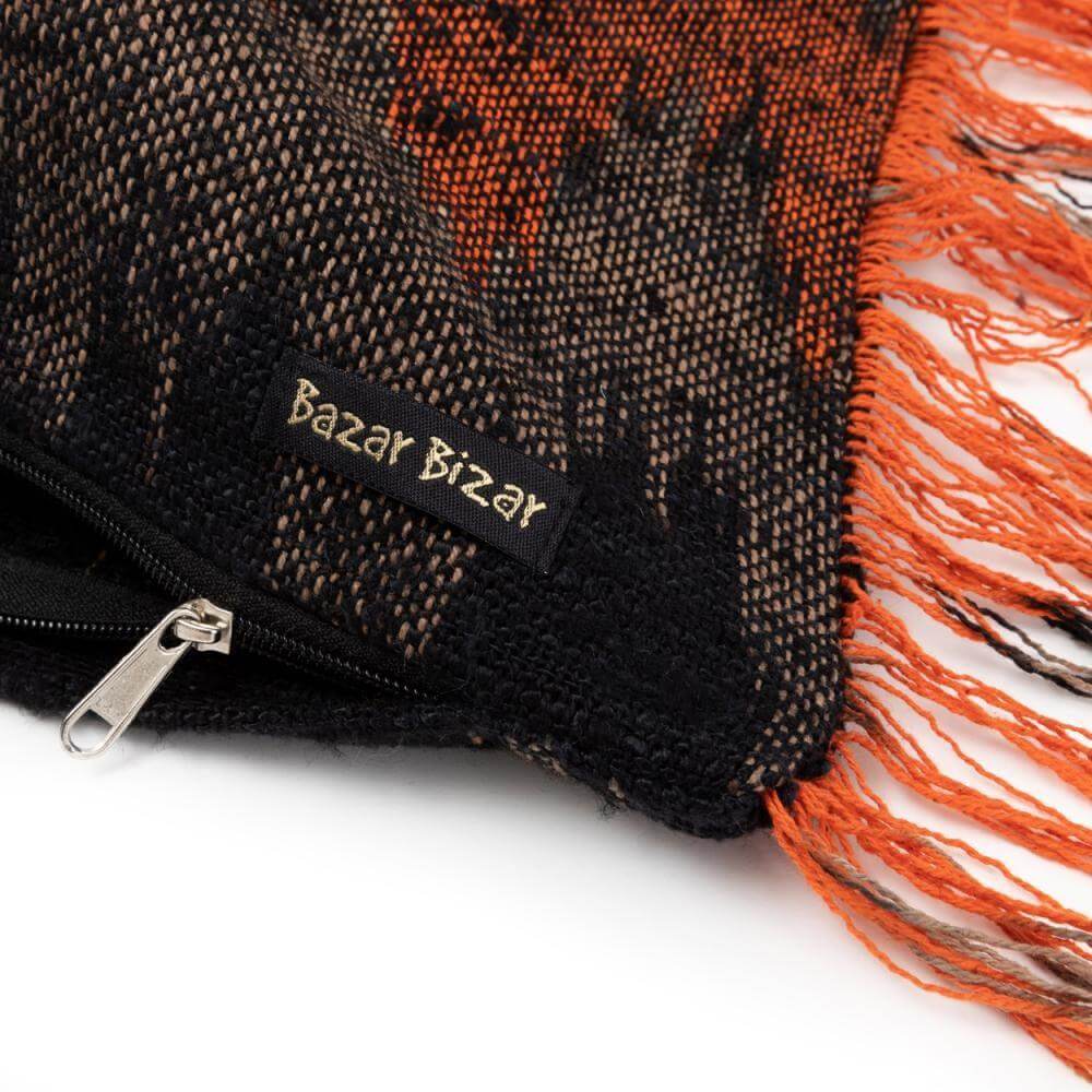Alt Tag: De Oh My Gee kussenhoes zwart oranje met franjes, 30x50 cm, voor een boho touch in interieur, detail van ritssluiting.
