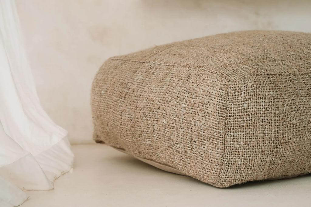 Beige katoenen poef in zachte stijl voor huis- of buitenruimte, handgemaakt en duurzaam, accentueel en functioneel.