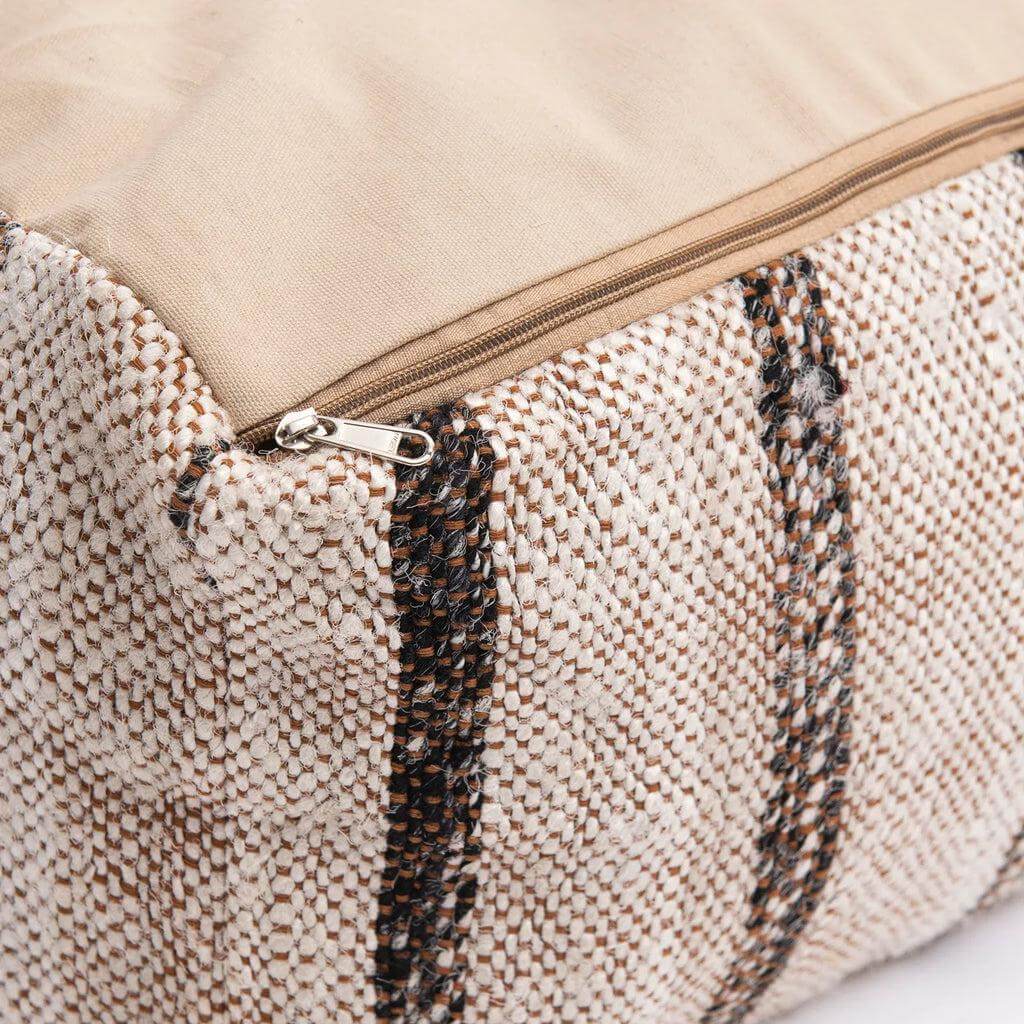 Detail van bohemian katoenen poef met ritssluiting in beige en bruine tinten, perfect voor stijlvol comfort in huis of overdekte buitenruimtes.