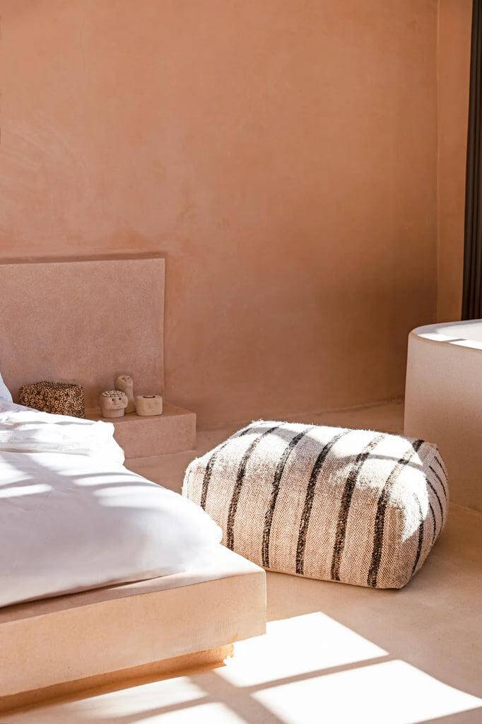 Bohemian katoenen poef in witte kleuren in een rustgevende slaapkamer. Comfortabel en stijlvol interieuraccent.