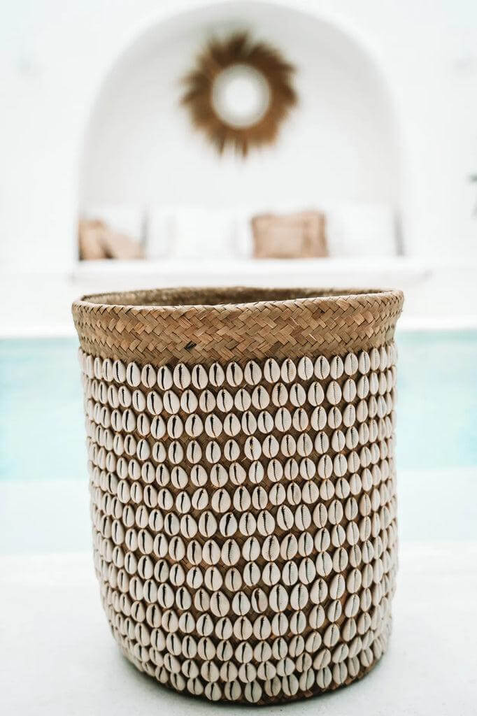 Prachtige handgemaakte mand van pandanplant met Balinese schelpen, ideaal voor wasgoed of planten. Natuurlijke witte tint.