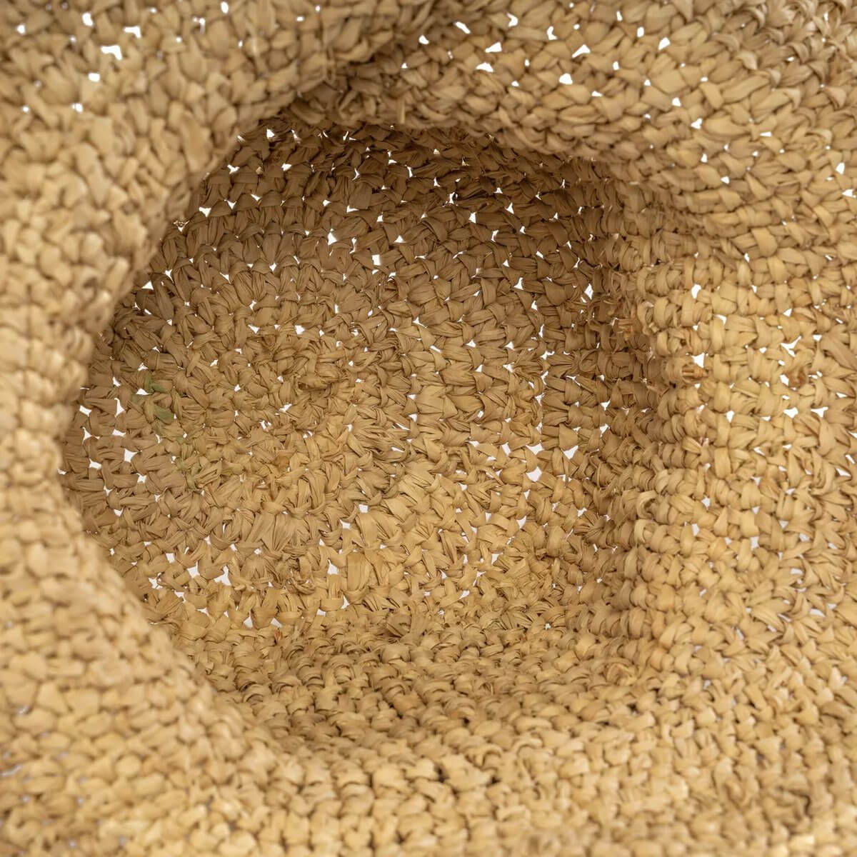 Close-up of a woven Bohemian-style de Pantai-hoed made from natural sea grass, perfect for keeping cool at the beach.