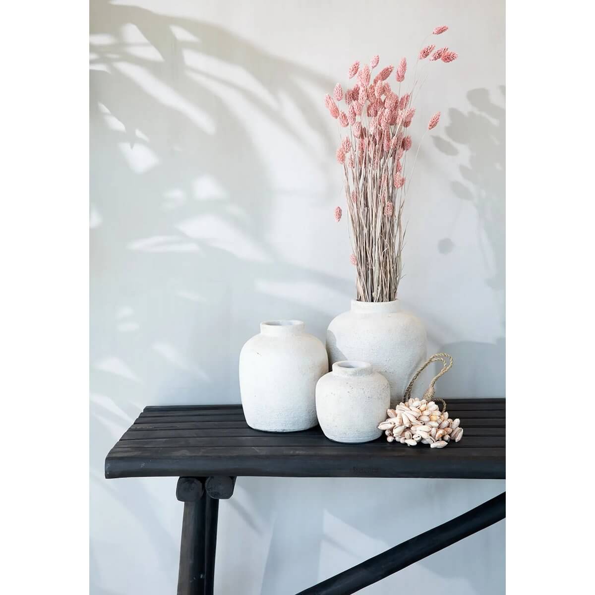 Bohemian Peaky Vaas Beton in stylish setting with soft pink dried flowers, showcasing terracotta charm on wooden table.
