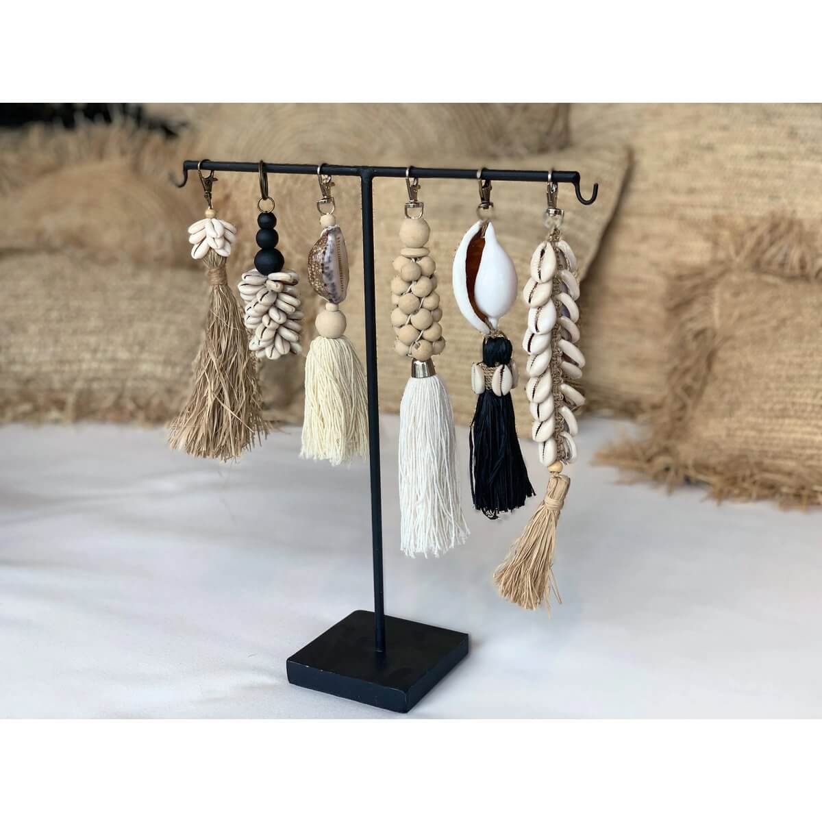 Display of artisan raffia keychains with intricate designs and coastal charm, highlighting the natural white Bohemian Fishbone Keychain.