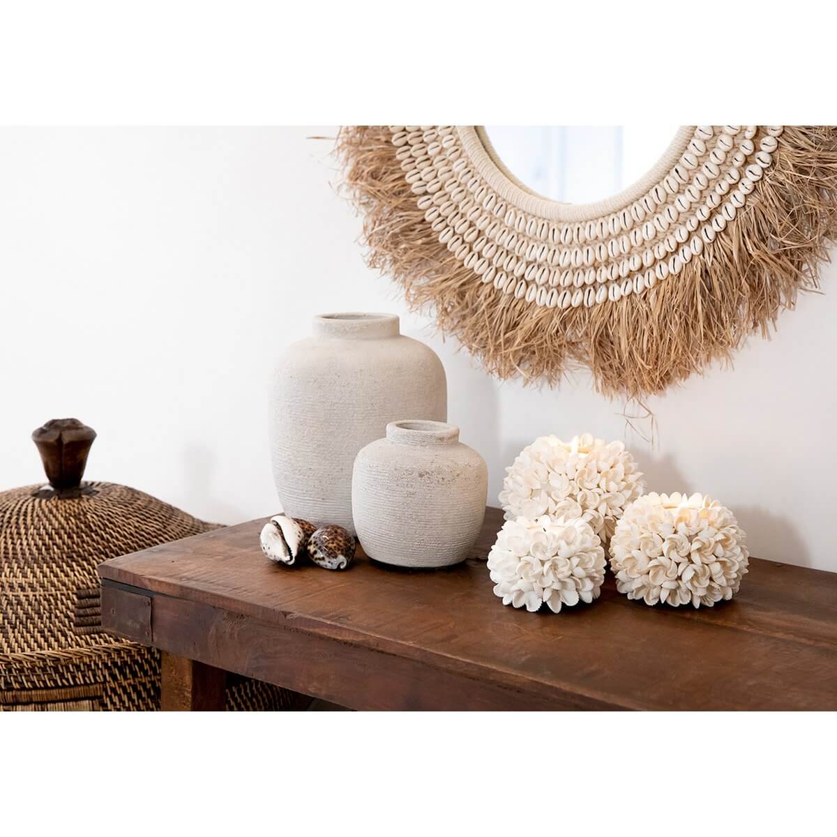 De Raffia Kauri Spiegel in Natuurlijk Wit, a bohemian wall decor with organic raffia and shell textures, enhancing coastal decor vibes.