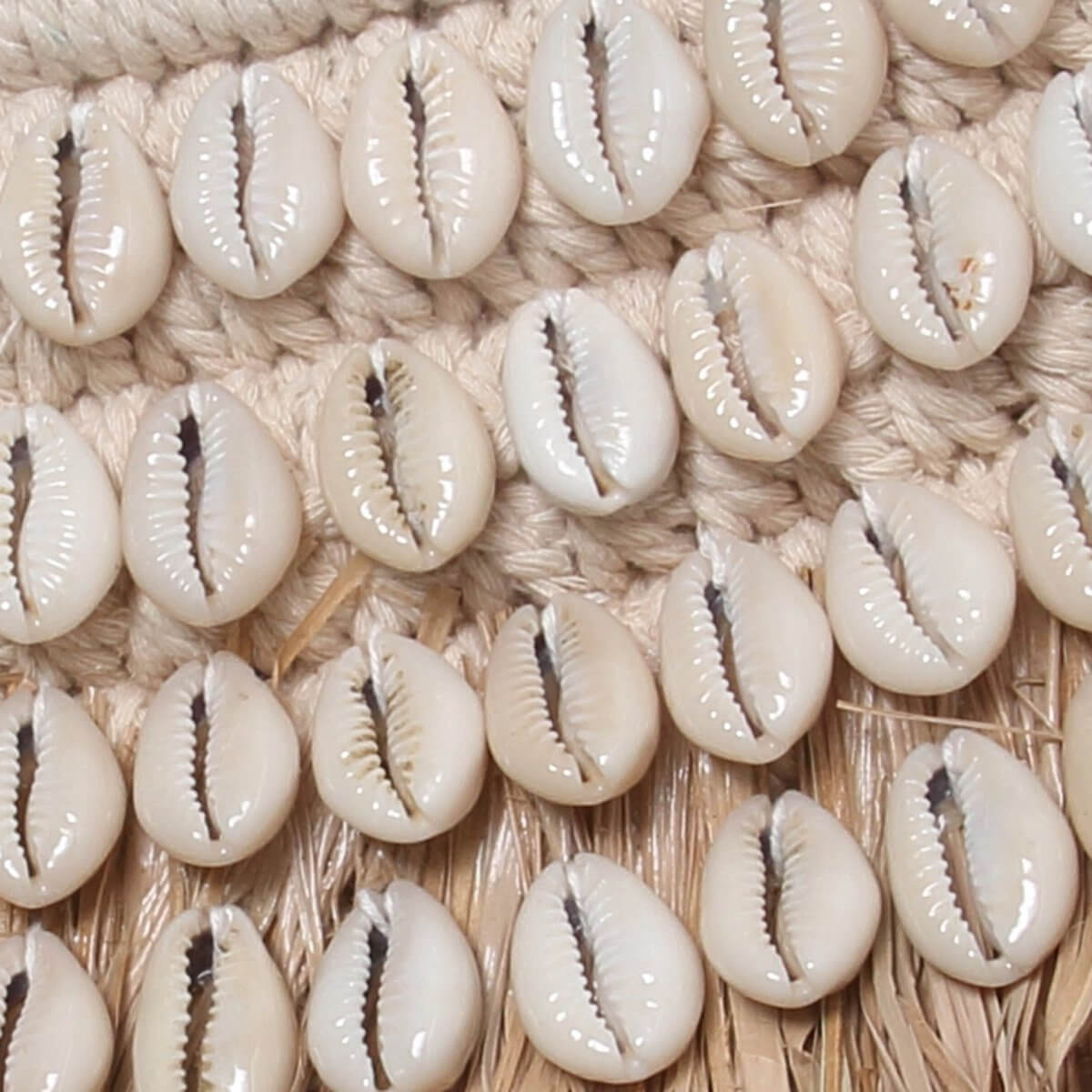 Close-up of De Raffia Kauri Spiegel with elegant beige shells and raffia, embodying a bohemian coastal design.
