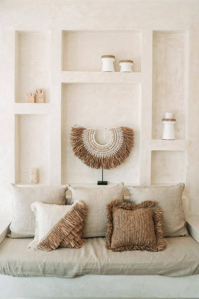 Woonkamer met natuurlijke raffia kussenhoezen en stijlvolle wanddecoratie, perfect voor een bohemien interieur.