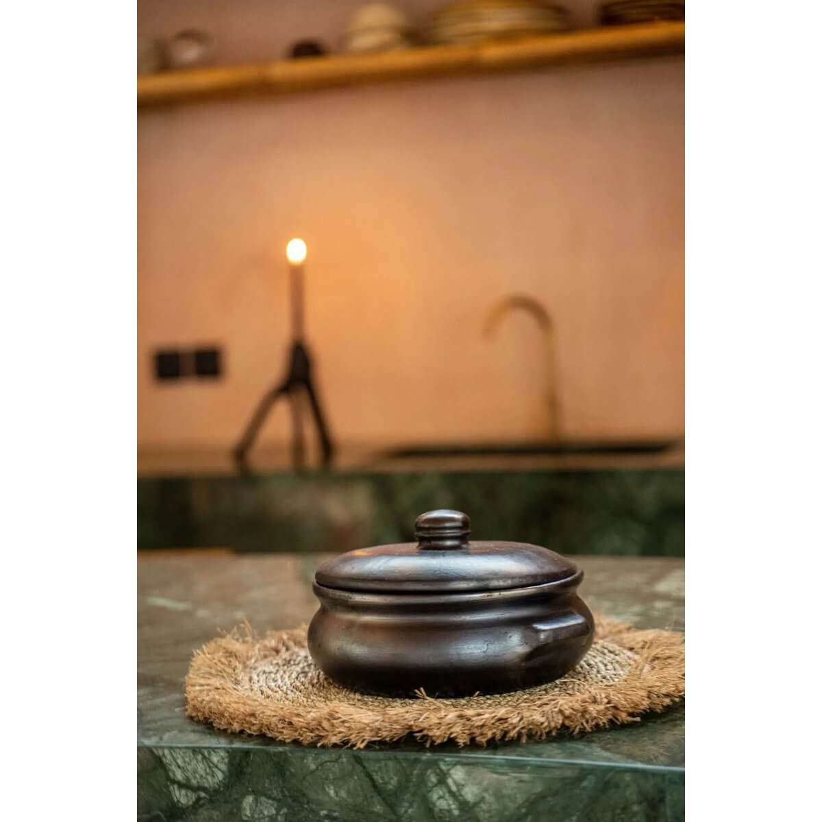 Bohemian style kitchen with dark clay dish on De Seagrass Raffia Placemat adding tropical charm and cozy vibes.