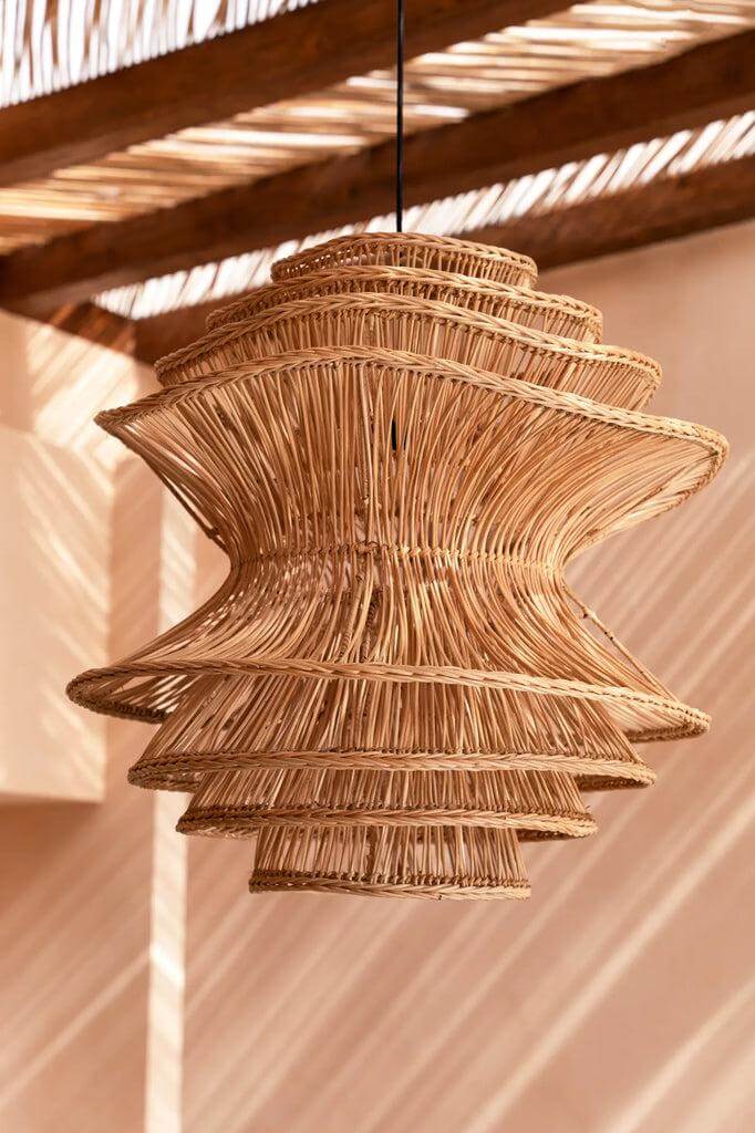 De Shiitake Hanglamp in naturel rotan, handgemaakt door Balinese ambachtslieden. Unieke organische vorm voor speelse patronen.