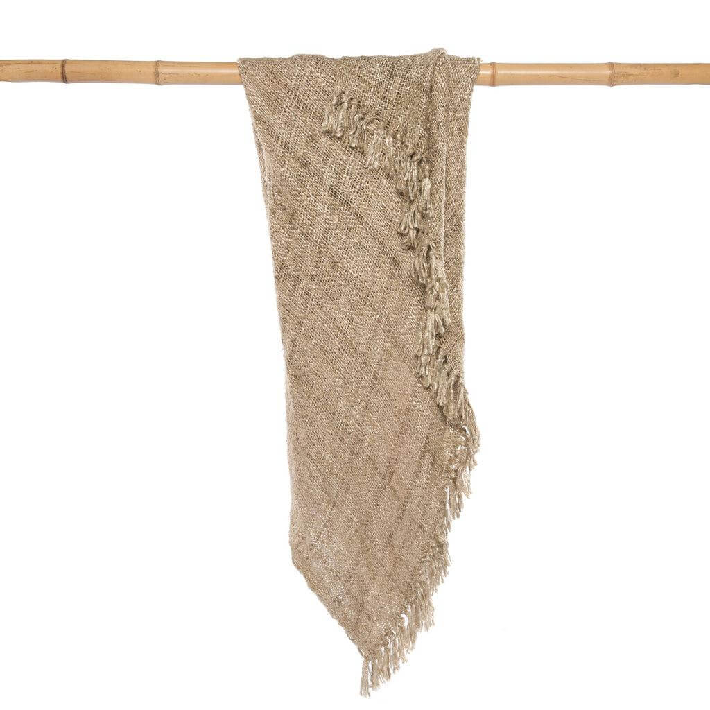 Luxe beige katoenen plaid met franjes en gewafelde structuur, perfect voor gezellige avonden op de bank of slaapkamer.