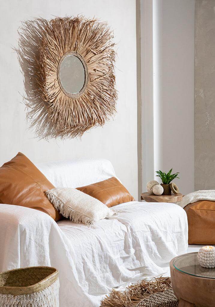 Gezellige woonkamer met witte bank, crèmekleurig plaid en sierkussens, ingericht voor een warme en sfeervolle ambiance.