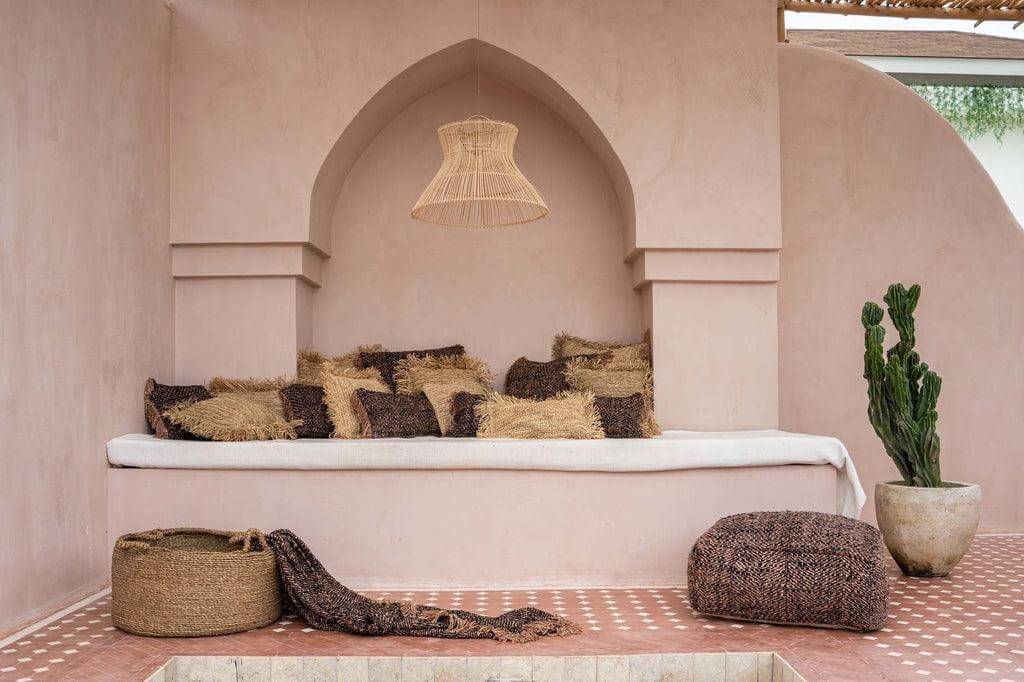 Gezellige zithoek met kussens, plaid en rustieke elementen in een boho-stijl interieur.