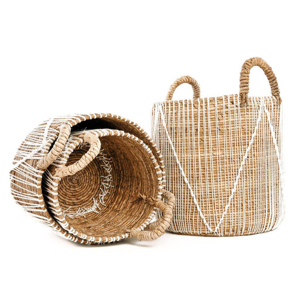 Natuurlijke zeegras manden versierd met witte macramé voor opslag en decoratie, beschikbaar in verschillende maten.