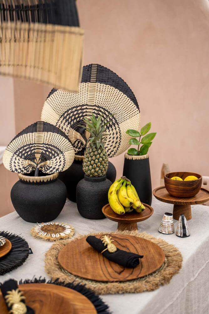 Decoratieve eettafel met De Styly Vaas in zwart en naturel, gevuld met exotisch fruit en plantaardige accenten voor kustsfeer.